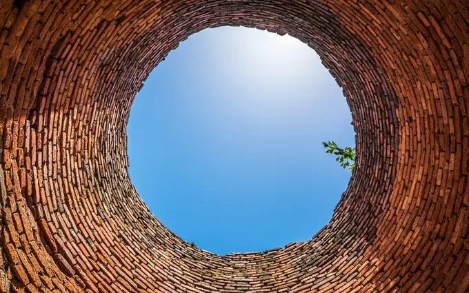 Privire de pe fundul unei fântâni zidite, spre cerul albastru